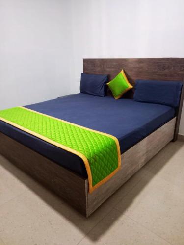 a bed with a blue and green comforter and pillows at Private 3BHK Villa with a Parking, WiFi, BBQ in Kodaikānāl