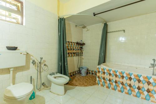 Lov Heritage Goa في Chinchinim: حمام مع مرحاض ودش وحوض استحمام