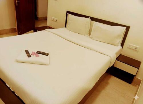 ChanakにあるHotel O Swami Vivekananda University Kolkataの白い大型ベッド(リモコン付)