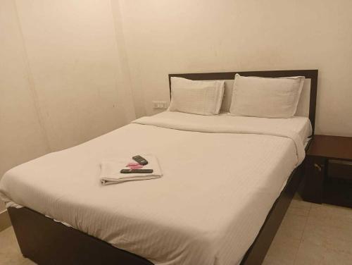 ChanakにあるHotel O Swami Vivekananda University Kolkataのカミソリが置かれたトレイが置かれたベッド