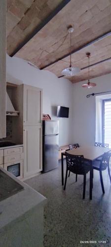 a kitchen with a table and a kitchen with a refrigerator at Civico 95 Alloggio Turistico in Marta