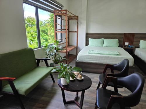 a bedroom with a bed and a couch and a table at Rami Xanh Stay in Danang