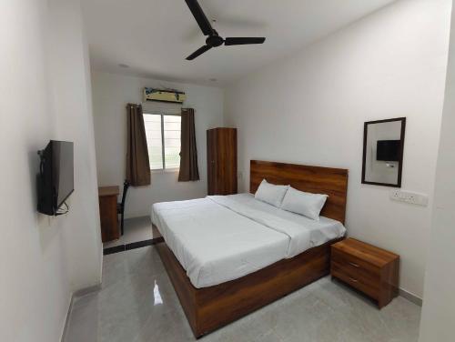 DeolāliにあるHotel O Nashik Road Railway Stationのベッドと薄型テレビのある寝室