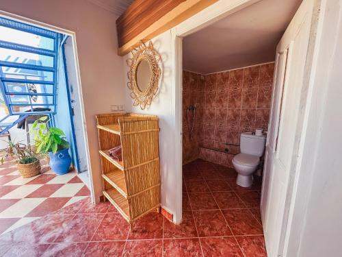 a bathroom with a toilet and a mirror on the wall at Freebird Surfcamp Morocco in Agadir