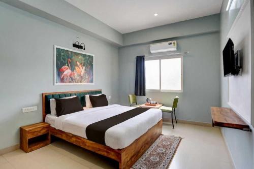 a bedroom with a bed and a table and a window at Collection O Kesar Crossway Jaipur Formerly Laxmi Palace in Jaipur