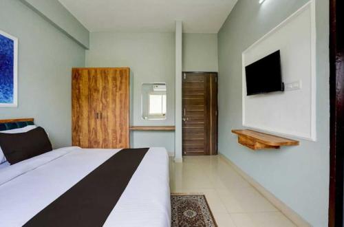 a bedroom with a bed and a flat screen tv at Collection O Kesar Crossway Jaipur Formerly Laxmi Palace in Jaipur