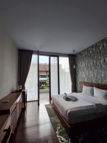 a bedroom with a large bed and a large window at The Castle Medan Penginapan Syariah in Medan