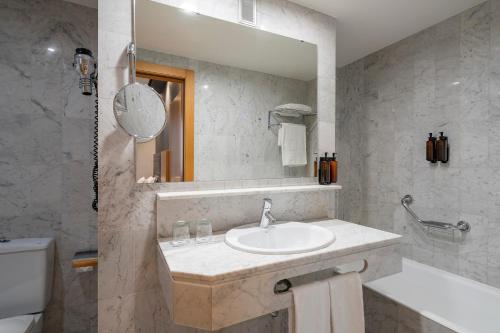 a bathroom with a sink and a mirror at Eurostars Indautxu in Bilbao