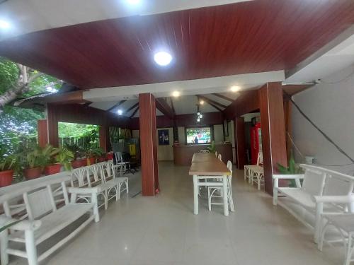 a restaurant with white chairs and a table and tables and chairs at Casa Felicisima Inn in Puerto Princesa City