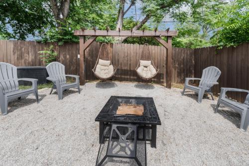 a backyard with a fire pit and chairs and a wooden fence at Stockyards- 4min Pet Friendly 3BR Luxe Gem in Fort Worth