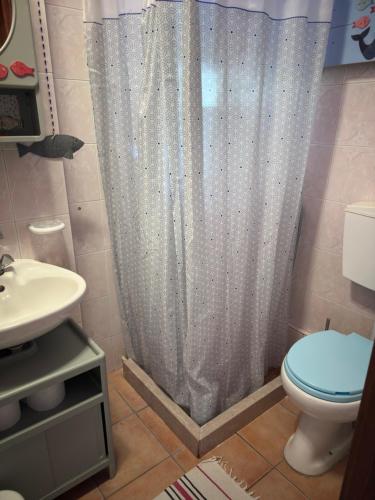 a bathroom with a toilet and a shower curtain at Η Μεγάλη Χαρούμενη Αρκούδα in Pávliani