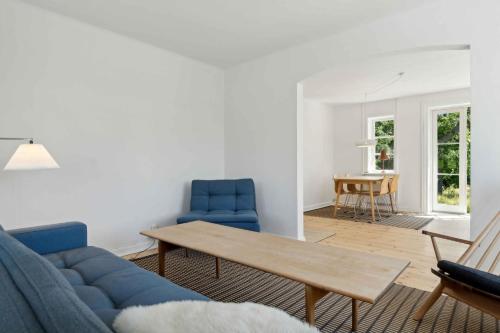 a living room with a blue couch and blue chairs at Old Local House From 1904 With Natural Garden in Tranekær