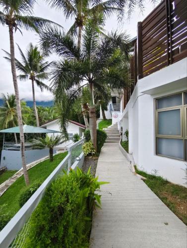 a walkway leading up to a house with palm trees at AV Suites in Puerto Galera