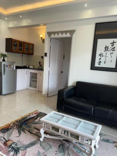 a living room with a black couch and a coffee table at Sea Breeze Bay in Calangute