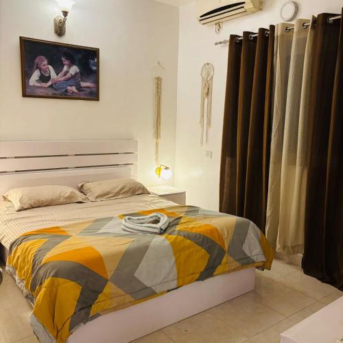 a bedroom with a bed and a painting on the wall at 1bhk in Calangute North Goa nearby beach Sea Breeze Bay in Calangute