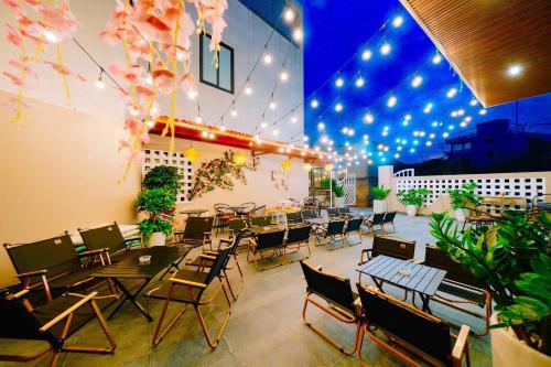 カットバ島にあるCatba SunWoo Homestay & Hotelのテーブルと椅子と照明のあるレストラン
