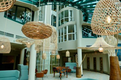 a lobby with chandeliers and a table and chairs at Hotel Amadeus Frankfurt in Frankfurt