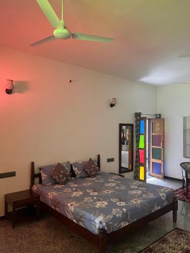 a bedroom with a bed and a ceiling fan at Chitrak stays Jawai in Bijāpur