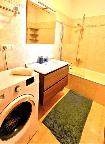 a bathroom with a washing machine and a sink at TT House Rho Fiera Milano Station in Rho