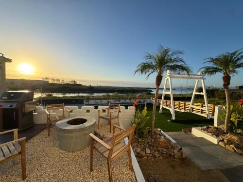 a patio with chairs and a grill and palm trees at Aoniwa Awaji - Sea, Sky, Swing in Awaji