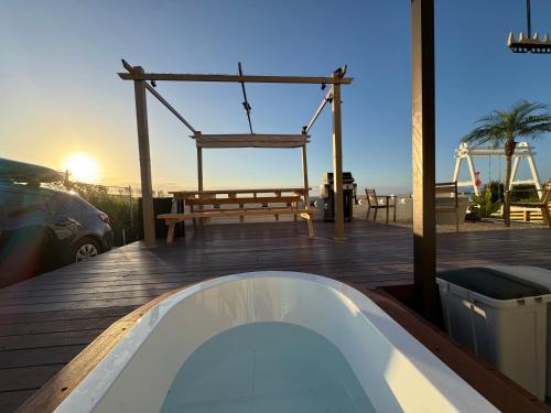 a hot tub and a swing on a deck with the ocean at Aoniwa Awaji - Sea, Sky, Swing in Awaji