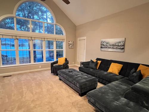 een woonkamer met een zwarte bank en 2 stoelen bij Modern 3br Lake front home in Johnsonville