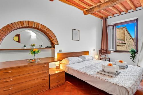 a bedroom with a bed with a dresser and a mirror at Casa Chopin - ToscanaOneHH in Laiatico