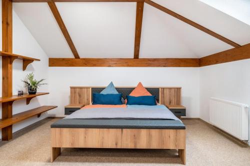 a bedroom with a bed with blue and orange pillows at Großes Ferienhaus Im Grünen - in Beselin