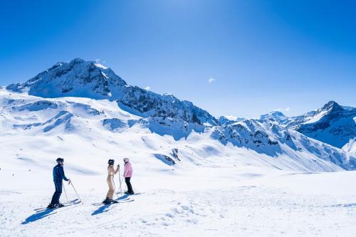 three people on skis on a snow covered mountain at Villages Clubs du Soleil - ARC 1800 in Arc 1800