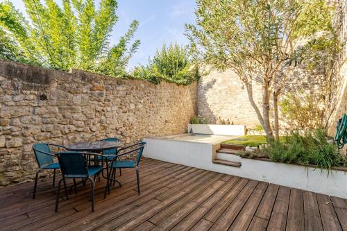 a patio with a table and chairs on a wooden deck at Cozy 2 bedroom house - 4 people in Bourg-Saint-Andéol