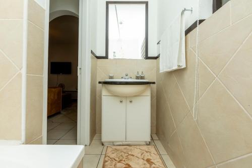 baño con lavabo y ducha con ventana en Sandton Luxury Apartment, 82 Via Arrezio, en Johannesburgo