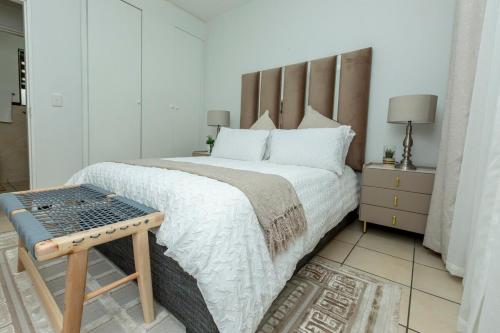 Un dormitorio con una cama grande con cabecero de madera. en Sandton Luxury Apartment, 82 Via Arrezio, en Johannesburgo