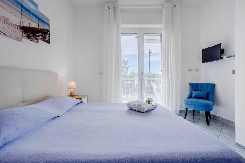 a bedroom with a bed and a blue chair at La pioggia nel pineto in Gaeta