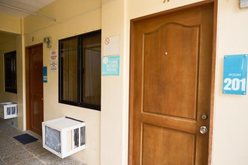 eine Tür in einem Gebäude mit einem Schild daneben. in der Unterkunft Iloilo Transient Rooms in Iloilo City