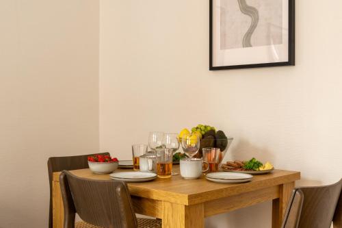 a wooden table with food and drinks on it at Homely 5 Person Apartment in Amager in Copenhagen