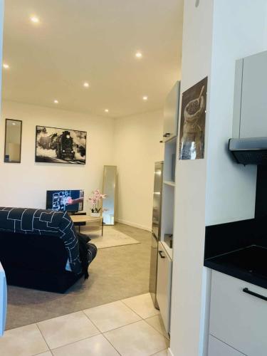 a living room with a couch and a tv at Cosy T2 CLIM FIBRE Centre ville RDC in Marmande