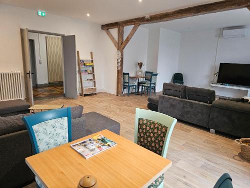 una sala de estar con una mesa y un sofá en Villa Milady Suite, en Salies-du-Salat