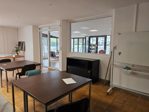 Una oficina con dos mesas y una pizarra y un aula. en Villa Milady Suite, en Salies-du-Salat