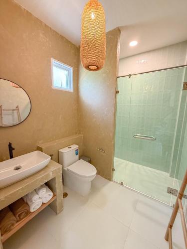 a bathroom with a shower and a toilet and a sink at The Palm Villa in Ban Ai Dao