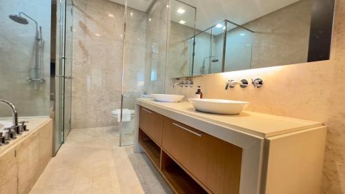 a bathroom with two sinks and a glass shower at Straits Quay Seaview in Tanjung Bungah