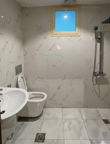 une salle de bain avec toilettes, lavabo et fenêtre dans l'établissement شقق نرمادا المفروشة 303, à Médine