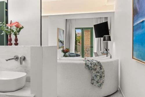 アテネにあるAthenaeum Eridanus Luxury Hotelの白いバスルーム(シンク、白い椅子付)