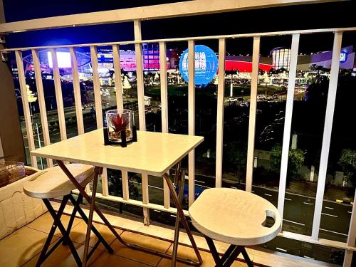 a table and two chairs on a balcony with a view at Staycation Near Mall of Asia in Manila