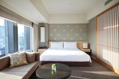 a hotel room with a bed and a couch at The Capitol Hotel Tokyu in Tokyo