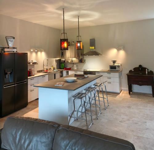 a kitchen with a large island with bar stools at La maison du lac in Saint-Martin-de-la-Mer