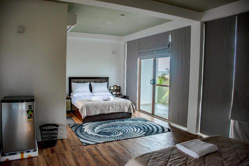 a bedroom with a bed and a large window at Sundowners in Chilaw