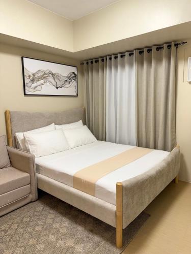 a bedroom with a large bed and a chair at Condo in Cagayan de Oro City in Cagayan de Oro