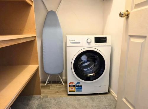a washing machine and a chair in a closet at The Studio on Ashtree in Armidale