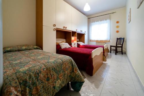 a hotel room with two beds and a window at Il Noccioleto in Linguaglossa