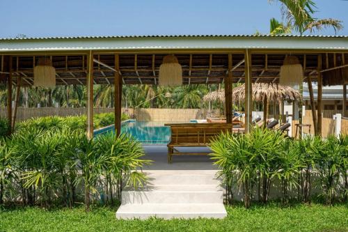 een resort met een zwembad en een tafel en stoelen bij The Palm Villa in Ban Ai Dao